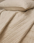 Harriet Home CoCashmere Quilted Coverlet in Ivory, showing the soft cotton-cashmere square quilted grid texture and neat folded drape.
