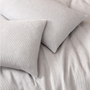 Close-up of the Harriet Home CoCashmere waffle quiltcover and pillows in Glacier Grey highlighting the fine square texture.