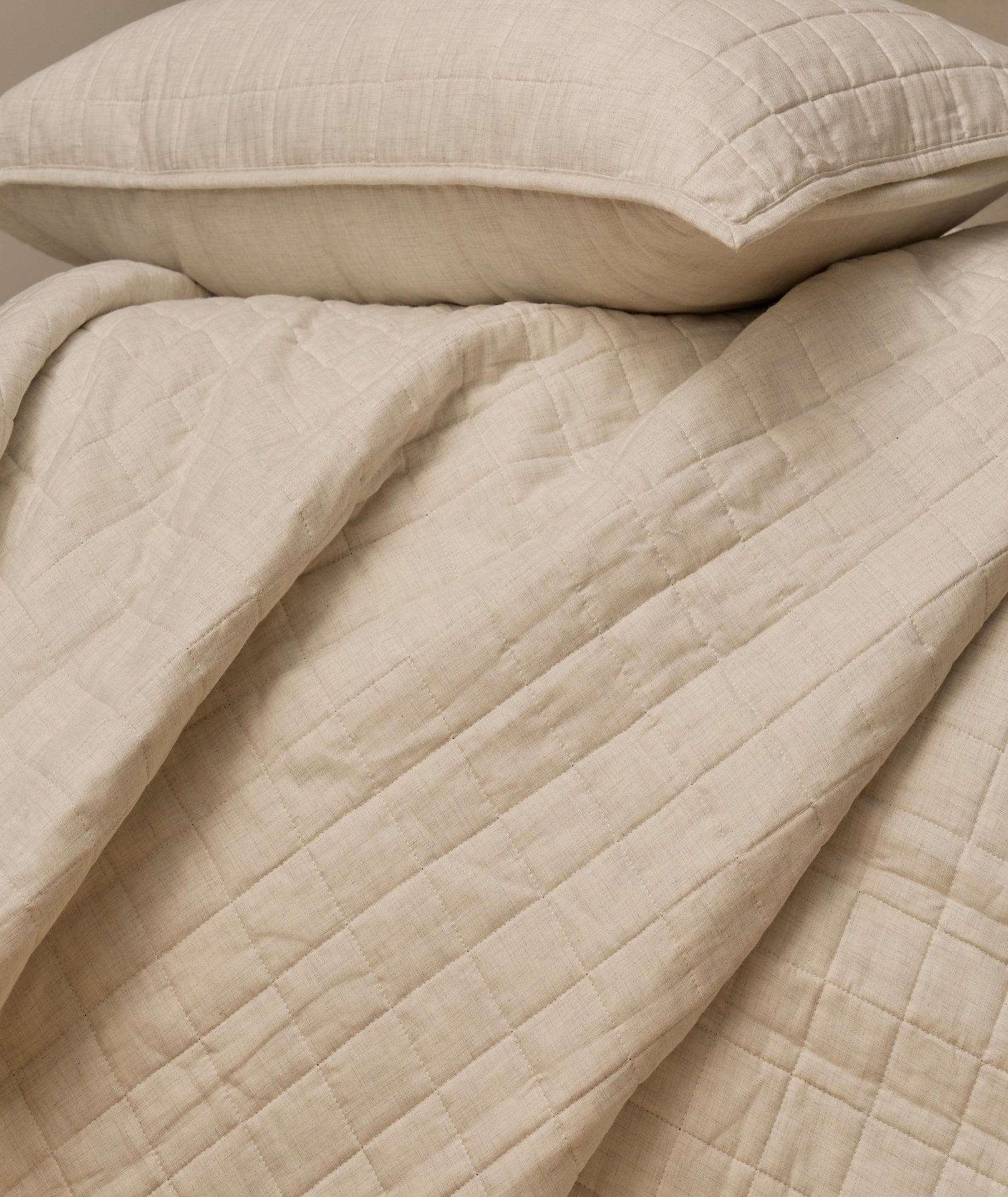 Harriet Home CoCashmere Quilted Coverlet in Ivory, showing the soft cotton-cashmere square quilted grid texture and neat folded drape.